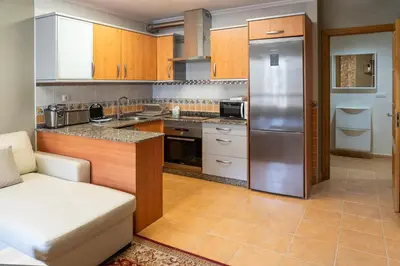a kitchen with a stainless steel refrigerator and cabinets at Apartamento cerca del centro, y la playa in Viveiro