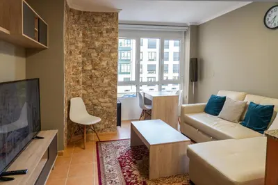 a living room with a couch and a table at Apartamento cerca del centro, y la playa in Viveiro