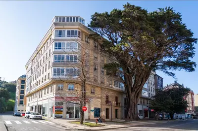 a tall building on the corner of a street at Apartamento cerca del centro, y la playa in Viveiro