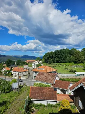 a small town with houses and a road and clouds at El pisito de iker in Mondariz