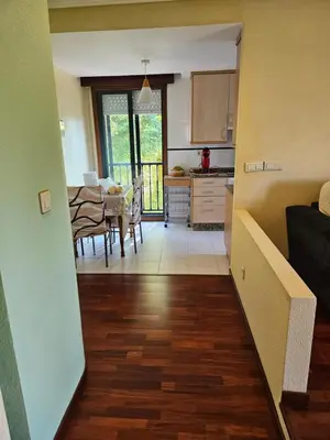 a kitchen with wooden cabinets and a white refrigerator at El pisito de iker in Mondariz