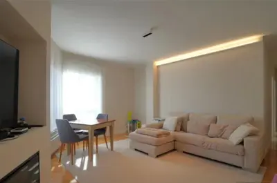 a living room with a couch and a table at Apartamento nuevo y cómodo in Guitiriz