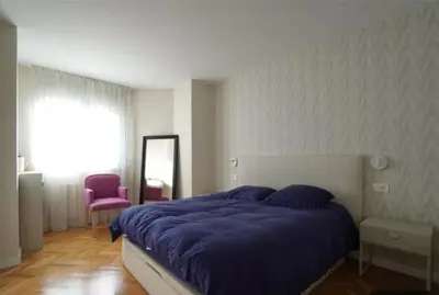 a bedroom with a large bed with a purple blanket at Apartamento nuevo y cómodo in Guitiriz
