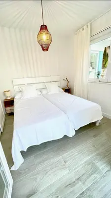 a white bedroom with a white bed and a chandelier at Villa Turquesa B in Viveiro