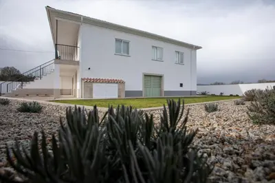 a white house with a green door in a yard at As Lavandas, Sober in Lobios