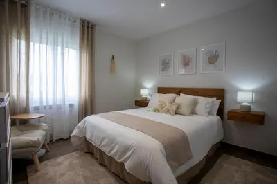 a bedroom with a large white bed and a chair at As Lavandas, Sober in Lobios