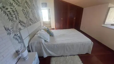 a small bedroom with a bed and a wall at Casa Kamelias in Moraña