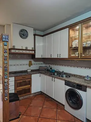 a kitchen with a table with chairs and a refrigerator at Casa Kamelias in Moraña
