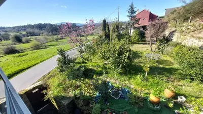a yard with two lawn chairs and a house at Casa Kamelias in Moraña