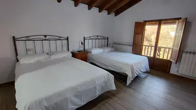 a bedroom with two beds and a window at Casa Rural Sanabria in Otero de Sanabria