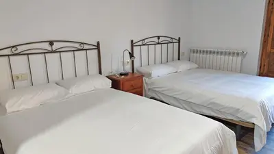 two beds sitting next to each other in a bedroom at Casa Rural Sanabria in Otero de Sanabria
