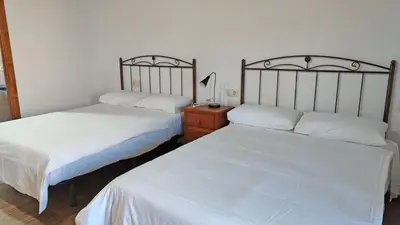 a bedroom with two beds and a table with a lamp at Casa Rural Sanabria in Otero de Sanabria
