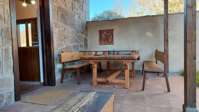 a wooden table and a bench on a patio at Casa Rural Sanabria in Otero de Sanabria