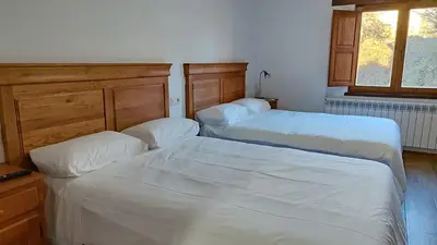 a bedroom with two beds and a window at Casa Rural Sanabria in Otero de Sanabria