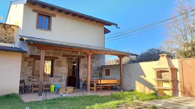 a house with a patio with a table in front of it at Casa Rural Sanabria in Otero de Sanabria