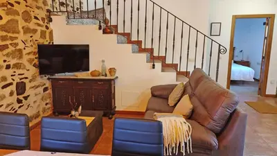 a living room with a couch and a tv at Casa Rural Sanabria in Otero de Sanabria