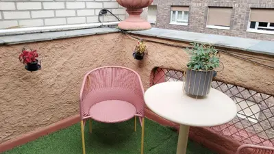 a balcony with two chairs and a table and potted plants at Cuarto Antolín Yellowdoor in Ponferrada
