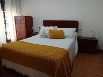 a bed with an orange blanket and pillows on it at Apartamento A Cañiza in La Cañiza