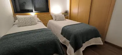 two beds in a small room with a window at Apartamento A Cañiza in La Cañiza