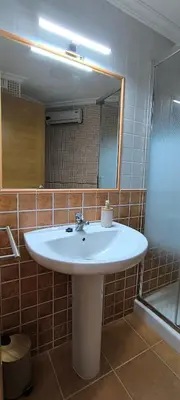 a bathroom with a white sink and a mirror at Apartamento A Cañiza in La Cañiza