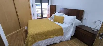 a small bedroom with a bed with a yellow blanket at Apartamento A Cañiza in La Cañiza