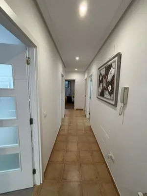 a hallway with white walls and a tile floor at Piso Carballal, Fantástico piso en pleno centro in Leiro
