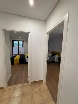 a room with two beds and a room with a hallway at Piso Carballal, Fantástico piso en pleno centro in Leiro