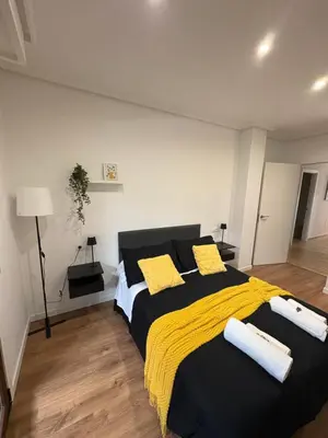 a bedroom with a large bed with yellow pillows at Piso Carballal, Fantástico piso en pleno centro in Leiro