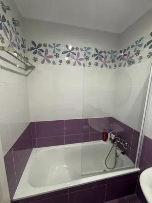 a bathroom with a tub with purple and white tiles at Piso Carballal, Fantástico piso en pleno centro in Leiro