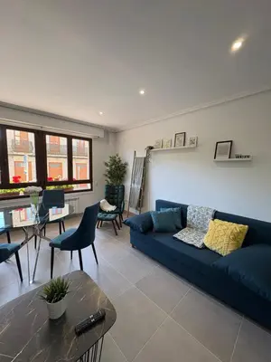 a living room with a blue couch and a table at Piso Carballal, Fantástico piso en pleno centro in Leiro
