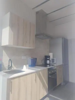a kitchen with wooden cabinets and a sink and a stove at Calm Stay in Teo