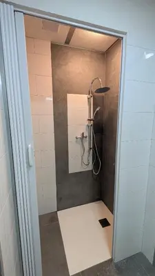 a shower in a bathroom with a glass door at Calm Stay in Teo