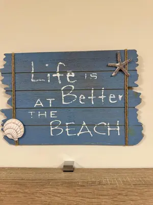 a sign that reads life is at better the beach at Apartamento Océano VI in Villadaíde