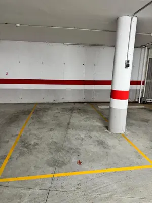 an empty parking garage with a red and white wall at Apartamento Océano VI in Villadaíde