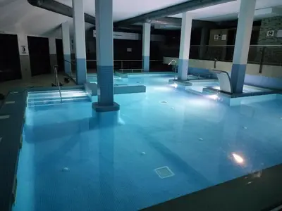 an empty swimming pool with blue floors and columns at Apartamento Herosa 2 Spa in San Miguel de Reinante