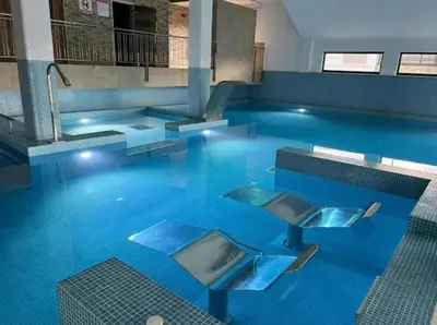 a swimming pool with two chairs in the water at Apartamento Herosa 2 Spa in San Miguel de Reinante