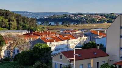 a view of a town with houses and a river at Apartamento CORAZÓN DE MIÑO in Miño