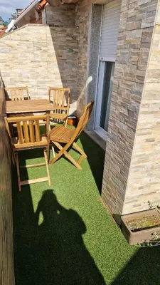 a patio with a table and chairs on the grass at Apartamento CORAZÓN DE MIÑO in Miño
