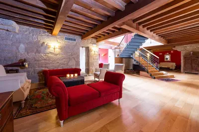 a living room with a red couch and a staircase at Abadía Caldaria in Arnoia