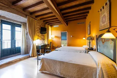 two beds in a room with yellow walls at Abadía Caldaria in Arnoia