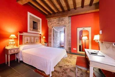 a bedroom with a white bed and red walls at Abadía Caldaria in Arnoia