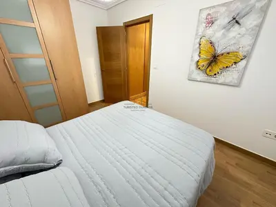 a bedroom with a bed with a butterfly painting on the wall at Termas de Ourense in Ourense