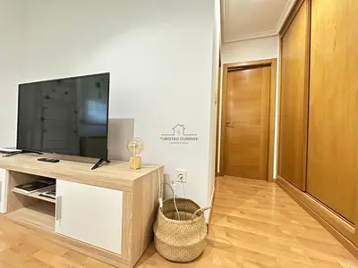 a living room with a flat screen tv on a entertainment center at Termas de Ourense in Ourense