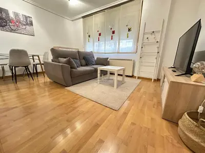 a living room with a couch and a tv at Termas de Ourense in Ourense
