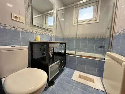 a bathroom with a toilet and a sink and a mirror at Termas de Ourense in Ourense