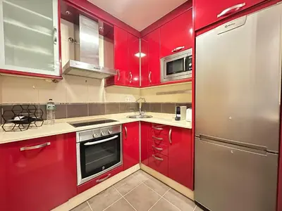 a kitchen with red cabinets and a stainless steel refrigerator at Termas de Ourense in Ourense