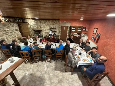 a group of people sitting at a table in a restaurant at A casa de Carmen in Sarria