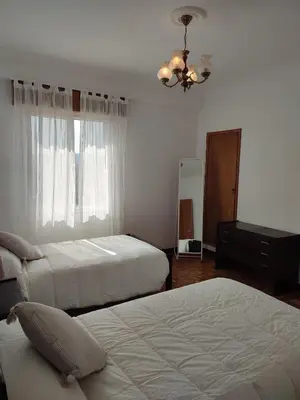 a bedroom with two beds and a dresser and a mirror at Piso Fenuca in Ourense