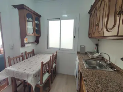 a kitchen with a table and a sink in it at Piso Fenuca in Ourense