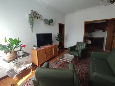 a living room with green chairs and a television at Piso Fenuca in Ourense